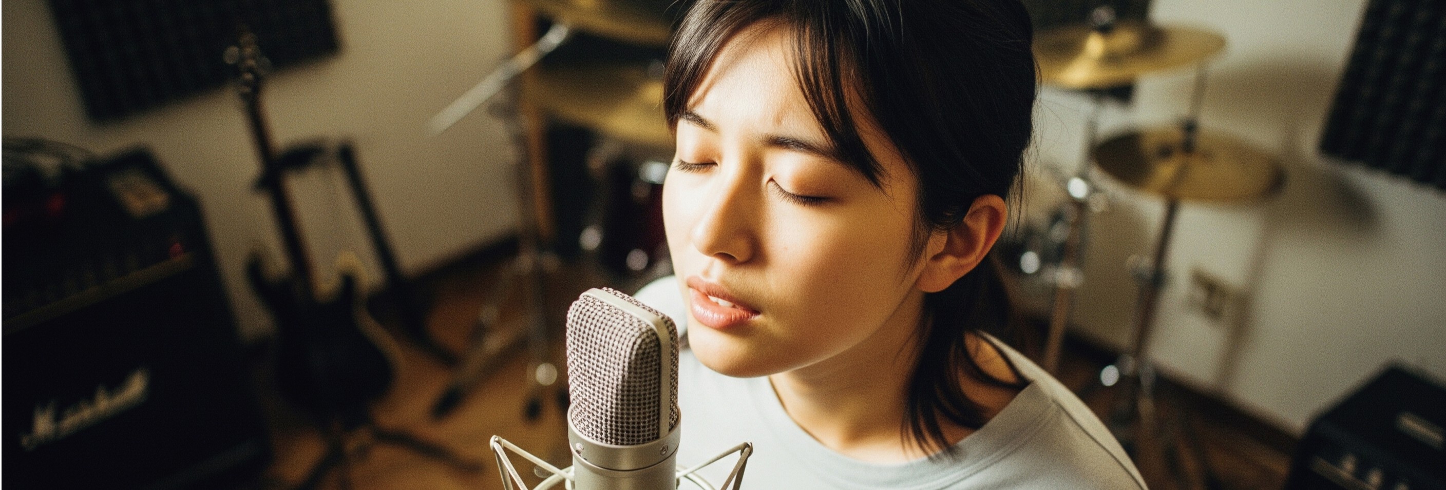 女性がマイクに向かって歌っている様子